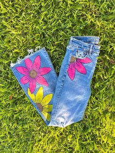 Bright and summery floral denim jeans are the perfect accent piece for your outfit of the day. Dress them up or dress them down they could go either way. This piece is customizable to your favorite pair of denim flares or bootcut jeans and features three large brightly colored flowers on the front with nothing on the back. Flowers can be added on the back for a small up-charge. For reference, I am a size  US 4 which is displayed in pictures. Jeans With Painted Flowers, Summer Cotton Flare Jeans, Spring Bohemian Wide Leg Flare Jeans, Trendy Flare Jeans For Spring, Bohemian Wide Leg Flare Jeans For Spring, Summer Denim Blue Cotton Flare Jeans, Spring Pink Denim Flare Jeans, Pink Denim Flare Jeans For Spring, Pink Spring Flare Denim Jeans