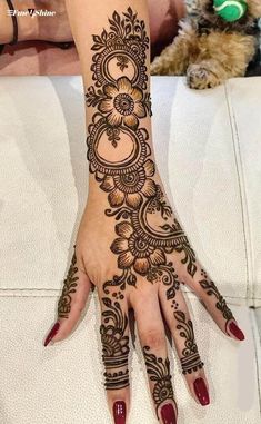 a woman's hand with henna tattoos on it