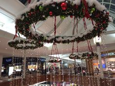 christmas decorations hanging from the ceiling in a shopping mall with lights and snow on them