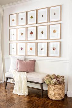 a white bench sitting in front of a wall with pictures on the wall above it