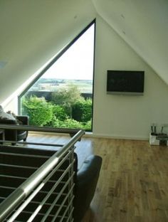 a living room filled with furniture and a flat screen tv on top of a wooden floor