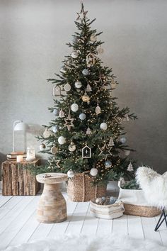 a small christmas tree with ornaments in baskets on the floor and other decorations around it