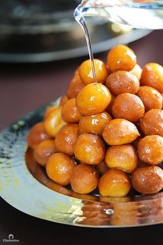 some kind of food that is sitting on a plate with water pouring from a spoon