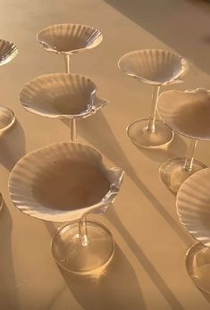 several wine glasses sitting on top of a table next to each other with saucers in them