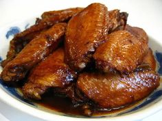 chicken wings with sauce in a blue and white bowl