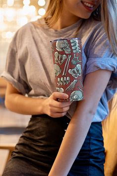 a woman is holding a case with skulls on it