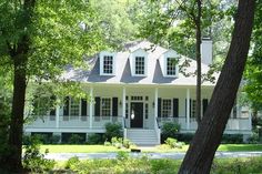 a white house surrounded by trees and grass