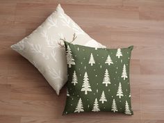 two green and white pillows sitting on top of a wooden floor next to each other