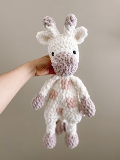 a crocheted giraffe stuffed animal being held by someone's hand