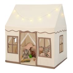 a toy house with lights on the roof and stuffed animals in it's windows