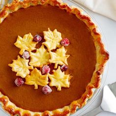 a pie with leaves and cranberries on top