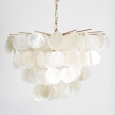 a chandelier made out of white rocks hanging from a chain