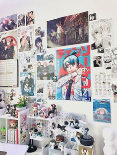 there are many pictures on the wall above the desk and in front of it is a shelf with various figurines