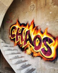 graffiti on the side of a building with stairs and fire coming out of it,