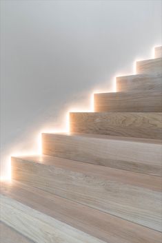 the light is shining down on some wooden stairs