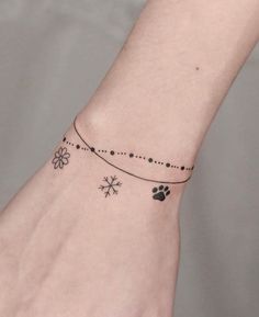 a woman's wrist with a dog paw and flower tattoo on it