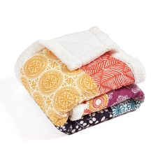 four blankets stacked on top of each other in different colors and patterns, all folded up