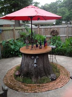 an umbrella is set up on top of a tree stump