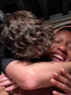 two people are hugging each other and smiling