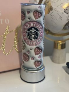 a starbucks cup sitting on top of a desk next to a globe