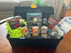 a black box filled with cleaning products on top of a wooden table