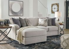 a living room scene with focus on the couch and chair, coffee table and stairs