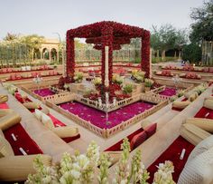 an outdoor wedding setup with red and white flowers