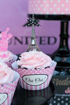 cupcakes with pink frosting in front of the eiffel tower