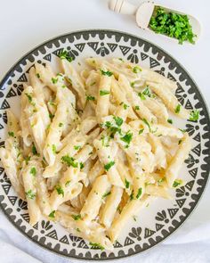 a white plate topped with pasta and parsley