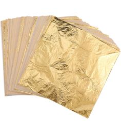 gold metallic foil sheets are stacked on top of each other, with one folded in the middle