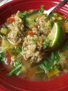 a red bowl filled with meat and vegetable soup