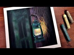 a painting of a green lantern on a wooden table next to crayon pencils