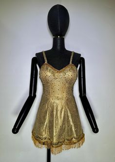 a mannequin wearing a gold dress with fringes