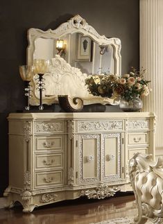 an ornate white dresser and mirror in a room