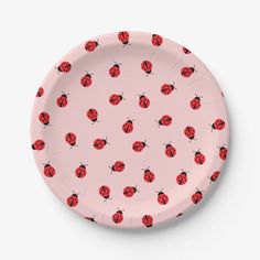 a pink paper plate with red ladybugs on it