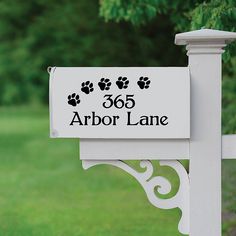 a white mailbox with black dog paw prints on it's front and side