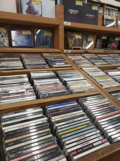 there are many cds on the shelves in this store that is filled with dvds and movies