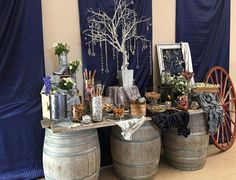 a table topped with two wooden barrels filled with candy and candies next to a tree