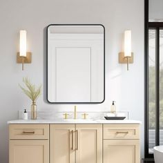 a bathroom vanity with two sinks and a large mirror above it, next to a bathtub