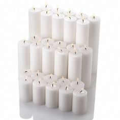 several rows of white candles with one lit in the middle and six on each side