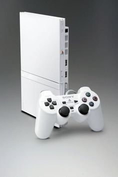 two video game controllers sitting next to each other in front of a white box on a gray background