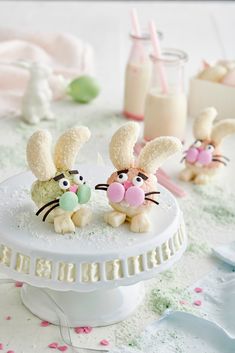 two small bunny cakes sitting on top of a cake plate