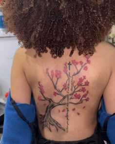 the back of a woman's upper body with tattoos on her chest and cross