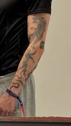 a man with a tattoo on his arm holding a tennis racquet