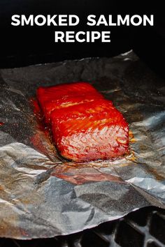 a piece of cooked salmon sitting on top of aluminum foil covered in ketchup