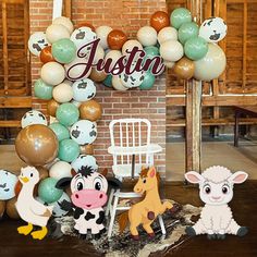 an animal themed birthday party with balloons and decorations on the wall, including farm animals