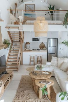 a living room filled with furniture and a fire place next to a stair case in front of a window