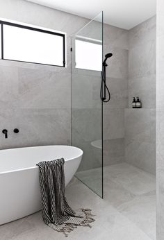 a white bath tub sitting next to a walk in shower