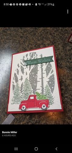 a christmas card with a red truck and trees