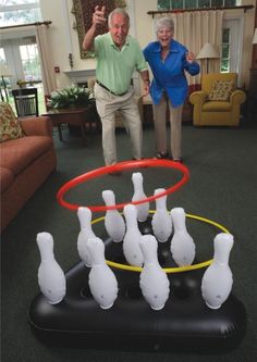 an older man and woman playing with plastic bowling pins